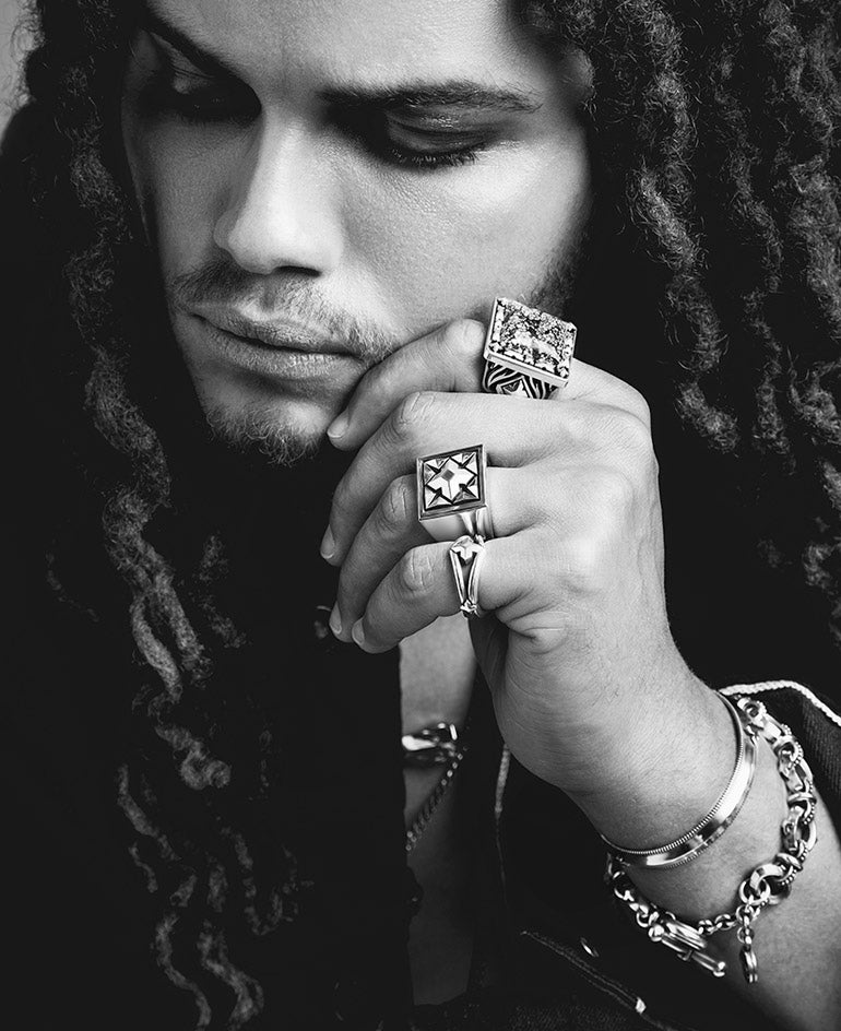 black and white image of a man wearing several rings